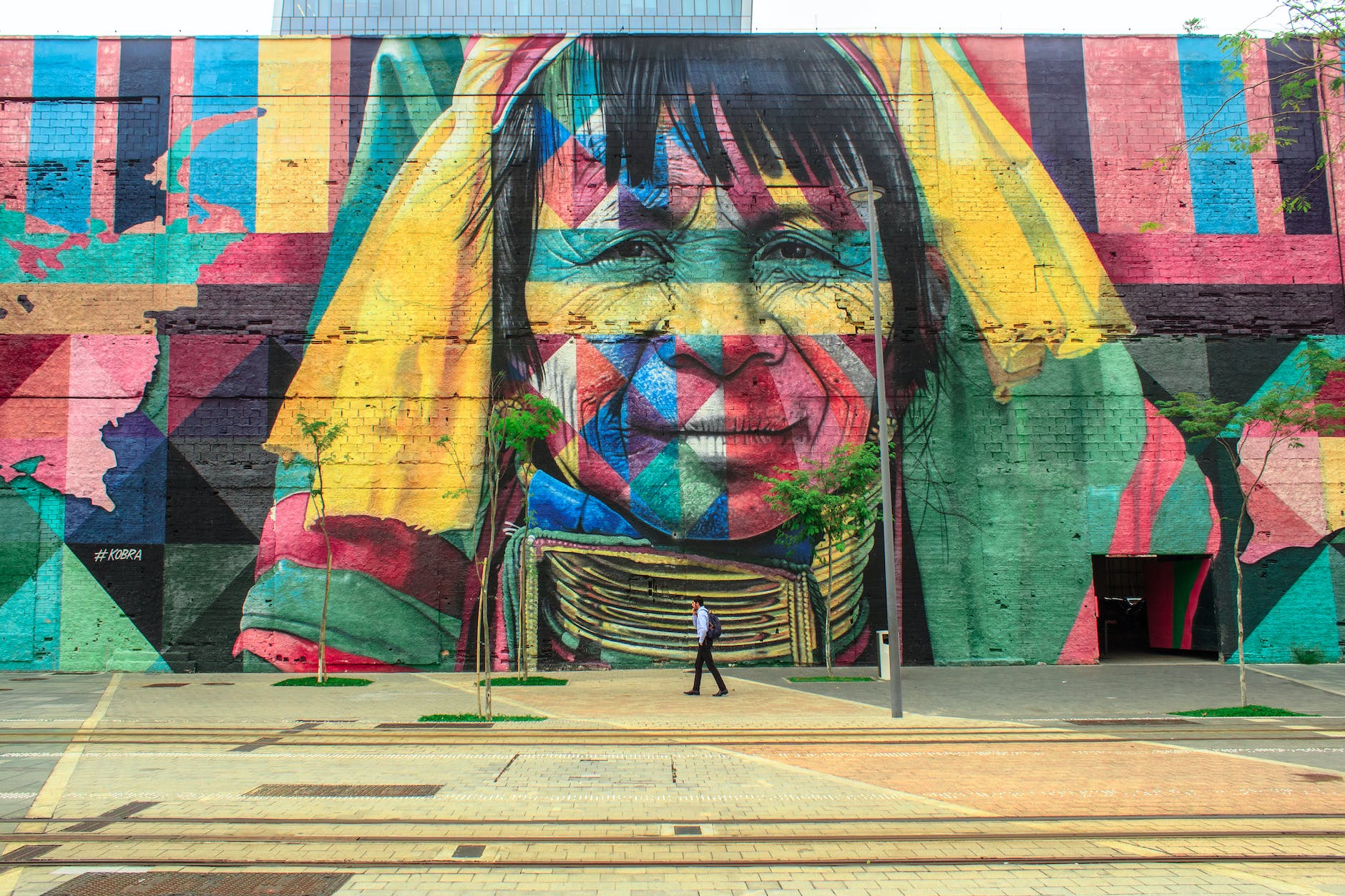 Colorful street art depiction of an indigenous person on a building.