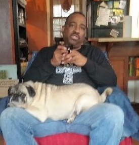 James sitting with a tan colored pug on his lap